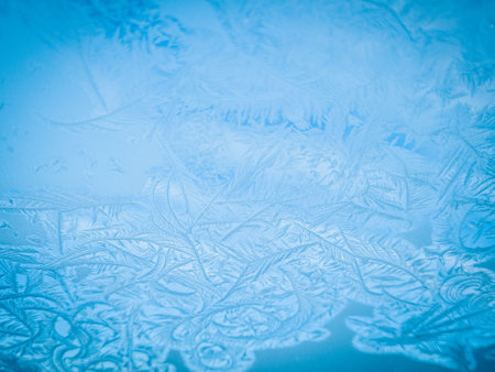 Frosty natural pattern on winter window glass. Abstract background.