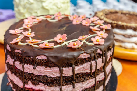 Close up of a chocolate cake decorated with flowers on a wooden table