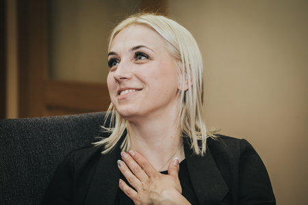 Portrait of a beautiful blonde woman in a black jacket. She is smiling.の写真素材