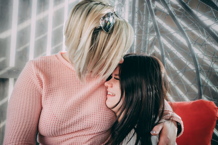 A daughter cries on her mothers shoulderの写真素材