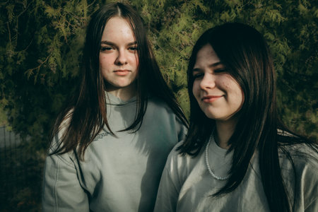 Portrait of two beautiful young women with long hair in the parkの写真素材