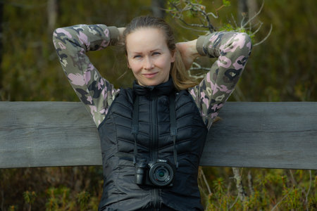 Portrait of a beautiful young woman with a camera in the forestの写真素材