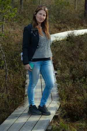 Beautiful young woman standing on a wooden walkway in the woodsの写真素材