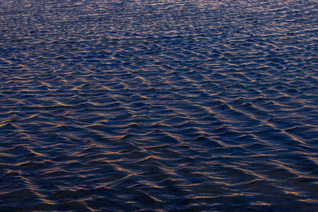 Ripples on the water at sunset as a background. Texture.の写真素材