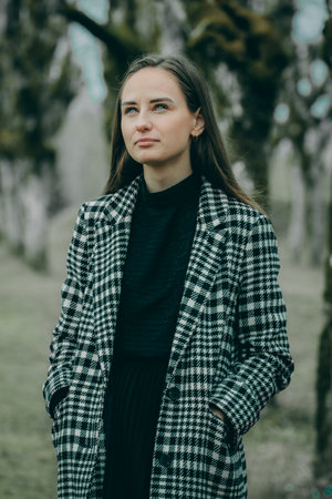 Portrait of a beautiful girl in a checkered coat in the parkの写真素材