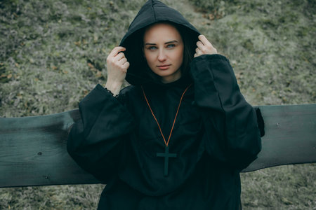 Portrait of a beautiful young woman in a black dress and a hoodの写真素材