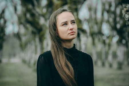Portrait of a beautiful young woman with long hair in the parkの写真素材