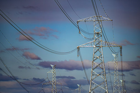 High voltage power lines against a blue sky. Electricity distribution station.の写真素材