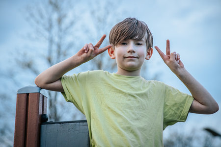 Portrait of a boy with his fingers in the shape of hornsの写真素材