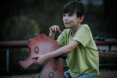 Cute little boy having fun on the playground. Outdoor portrait.の写真素材