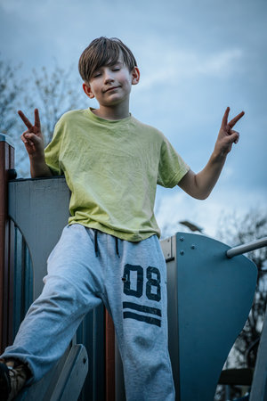 Portrait of a boy in a green T-shirt on the playgroundの写真素材
