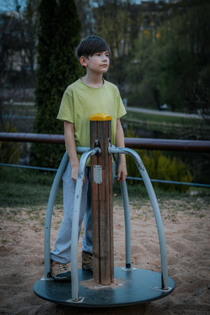 Little boy playing on a children playground in the park. Outdoor lifestyle portrait.の写真素材