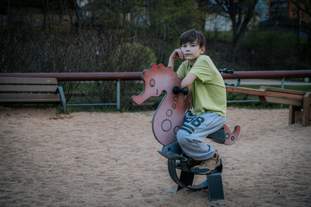 Little boy on a swing in the park. The concept of childhood and leisure.の写真素材