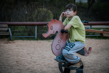 Little boy playing on a rocking horse in the park. Summertime.の写真素材