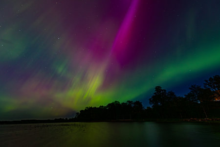 Aurora borealis, northern lights over lake in Finland.の写真素材