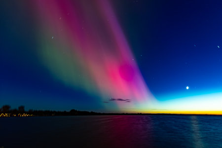 Aurora borealis in the night sky over the lake.の写真素材