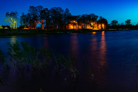 sunset on the river with blue sky and trees in the foregroundの写真素材