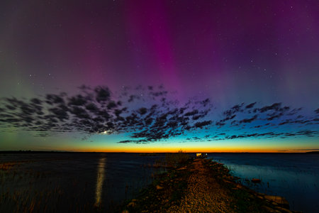 Aurora borealis in the night sky over the lake.の写真素材