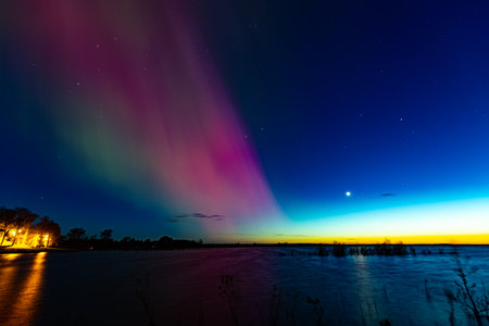 Aurora borealis in the night sky over the lake.の写真素材