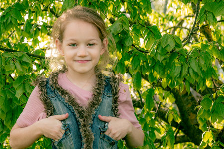 Portrait of a beautiful little girl in the park on a sunny dayの写真素材