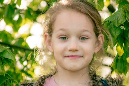 Portrait of a beautiful little girl in the garden. Selective focus.の写真素材