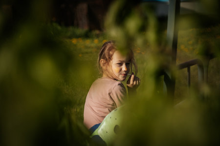 Little girl playing in the garden at sunset. Selective focus.の写真素材
