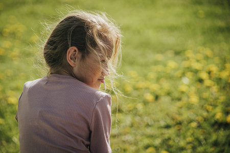 Portrait of a little girl on a meadow with dandelionsの写真素材