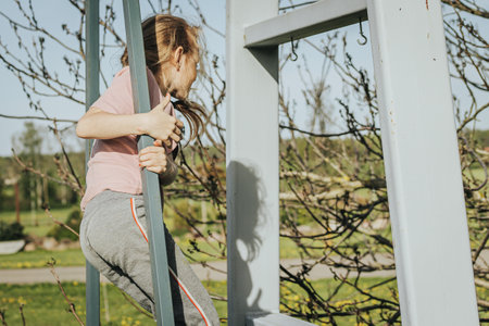 Young caucasian woman working out on a swing in the parkの写真素材
