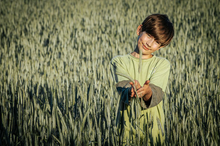 Portrait of a cute little boy in a wheat field. Happy childhood.の写真素材