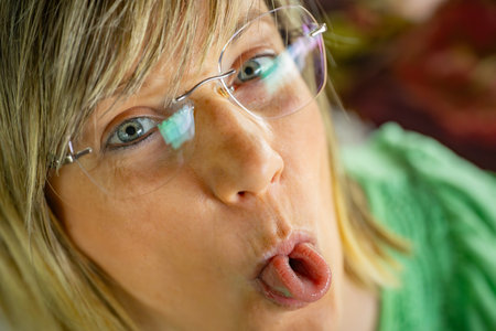 Portrait of a beautiful young woman with long blond hair and glassesの写真素材