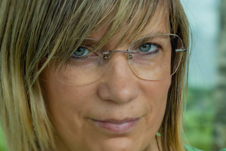 Portrait of a middle-aged woman with blond hair and glassesの写真素材
