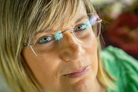 Portrait of a middle aged woman with eyeglasses looking at the cameraの写真素材