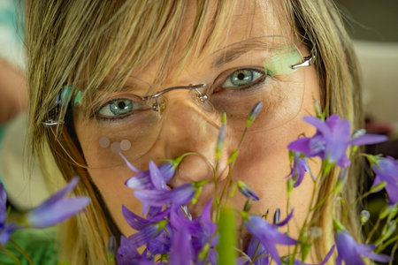Young woman with bluebells in her mouth, close-upの写真素材