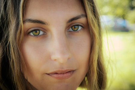 Close up portrait of a beautiful young woman with green eyes looking at cameraの写真素材