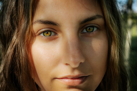 Close up portrait of a beautiful young woman with green eyes looking at cameraの写真素材