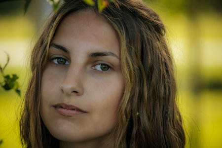 Portrait of a beautiful young woman with long brown hair and green eyesの写真素材