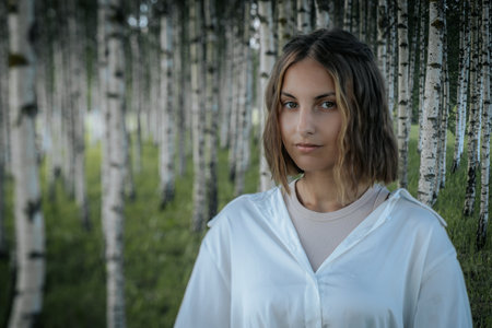 Portrait of a beautiful young woman in the birch forest.の写真素材