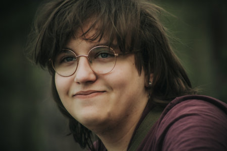 Portrait of a woman with glasses on a blurred background. Toned.の写真素材