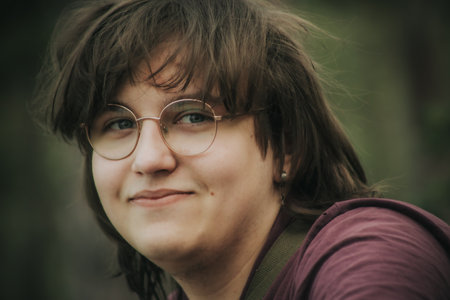 Portrait of a young woman with glasses in the park. Toned.