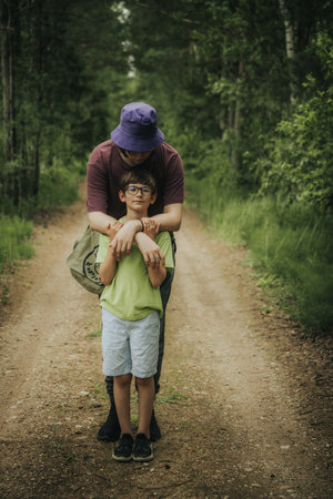 Father and son are hiking in the forest. Concept of friendly family.