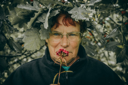 Portrait of an elderly woman in a wreath of flowers.の写真素材