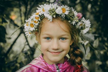 Portrait of a little girl in a wreath of daisiesの写真素材