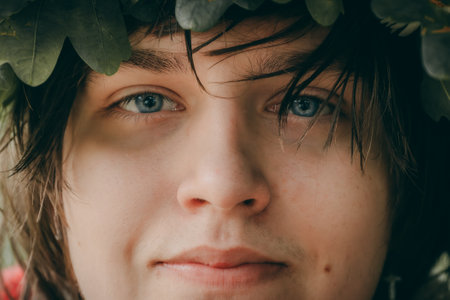 Portrait of a young man with green leaves in his hair.の写真素材