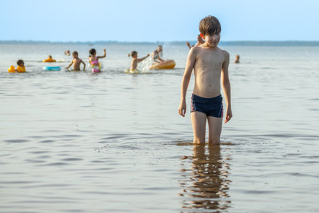 Boy playing in the water at the seaside on a hot summer dayの写真素材