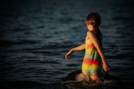 Girl in a bathing suit on the beach at sunset. Selective focus.の写真素材