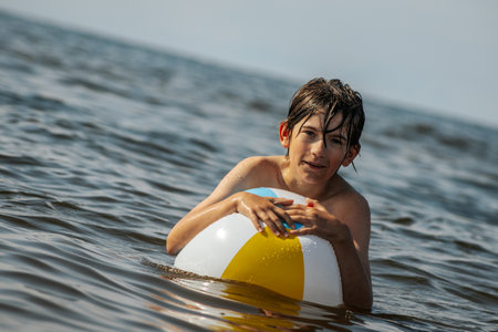 Portrait of a boy swimming in the sea with an inflatable ring