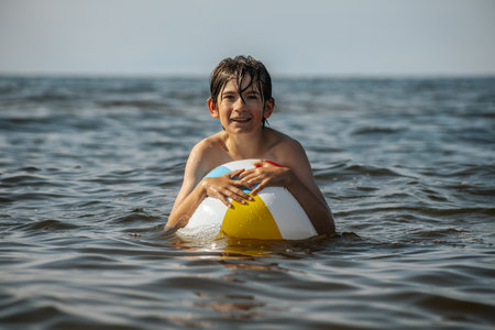 Boy in the sea with an inflatable ring in his hands.の写真素材
