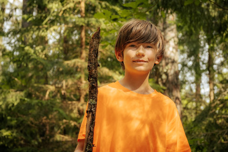Portrait of a boy in an orange shirt in the forest.の写真素材