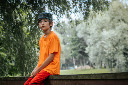 Portrait of a boy in an orange t-shirt and a hatの写真素材