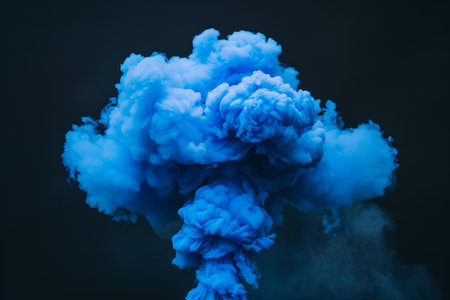 A dramatic burst of blue smoke expands against a solid black background, creating a striking contrast. The swirling, cloud like formation captures the dynamic motion and intensity of the explosion. AI generated.の素材